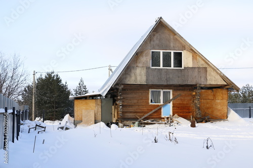 Дом на деревенской улице в снегу зимним днем