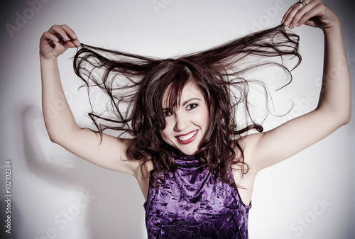 The beautiful funny girl with wild brown hairs. Stylized studio