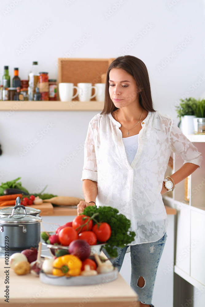 Young woman standing near desk in the kitchen Young woman standing near desk in the kitchen