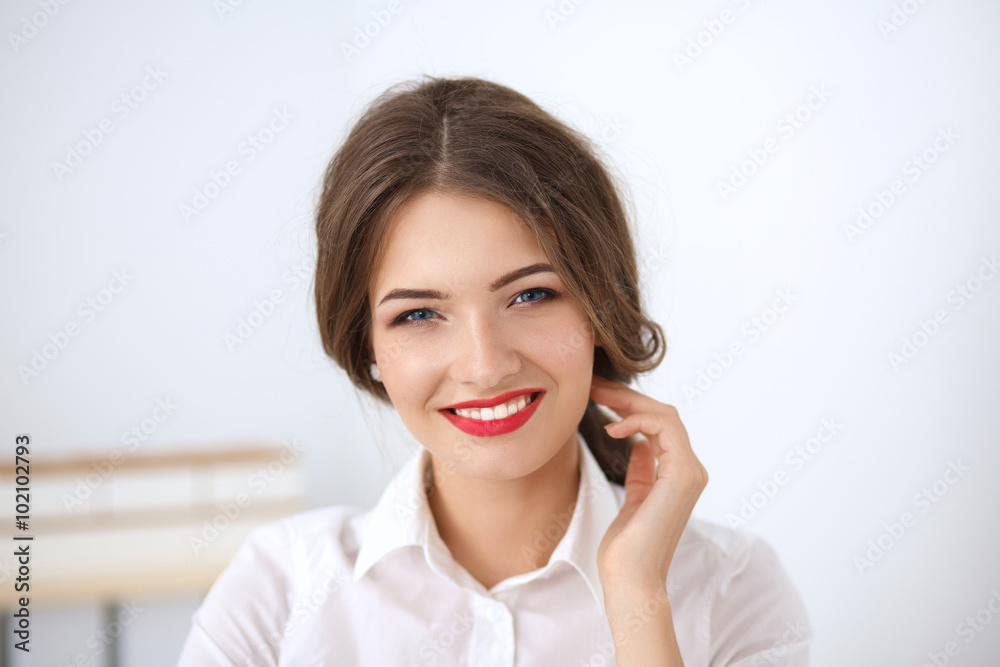 Attractive young businesswoman sitting in the office Attractive young businesswoman sitting in the office