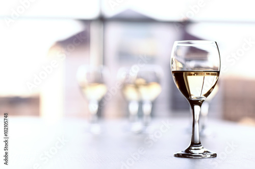 Glasses of wine on light blurred background