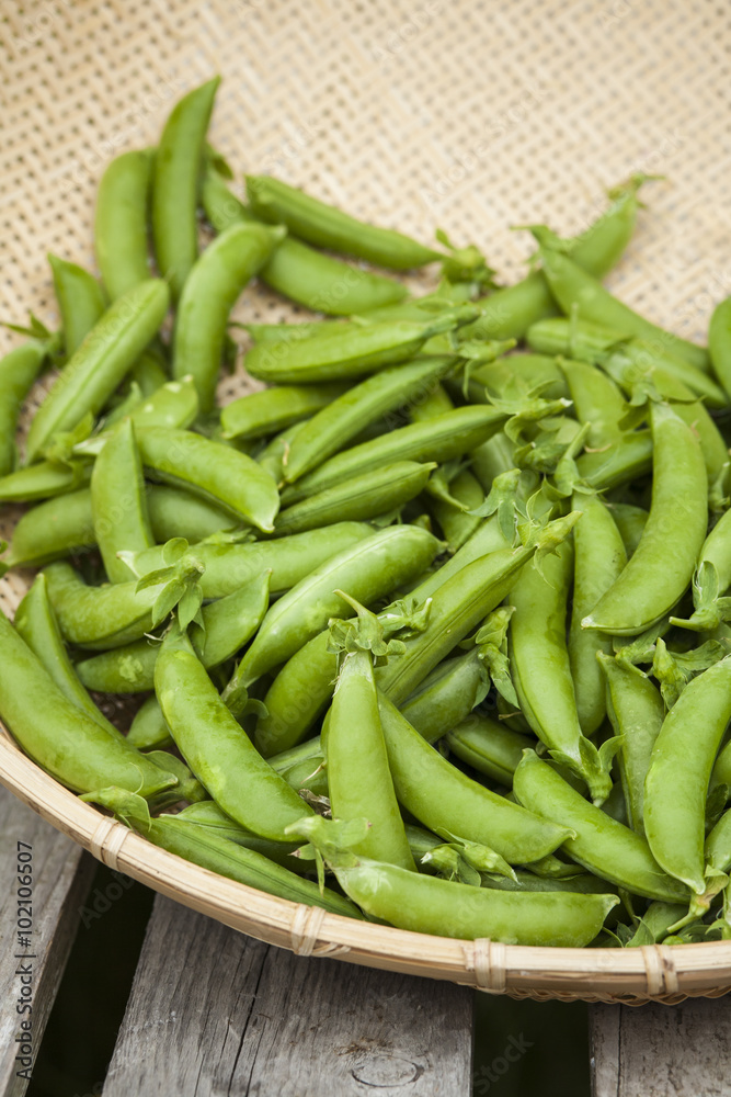 Organic snap peas in basket at farmers market Organic snap peas in basket at farmers market