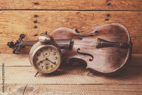 antykwarski-zegar-i-stare-skrzypce-nad-drewnianym-stolem-w-stylu-retro