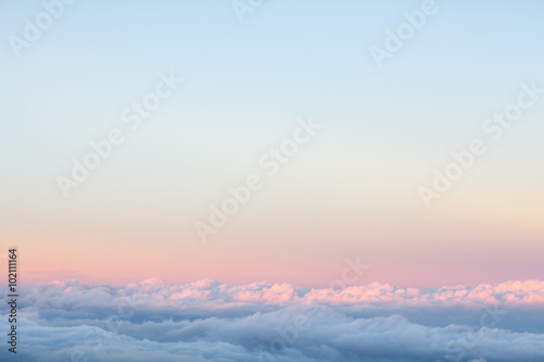 Background: above the clouds on beautiful sunset sky