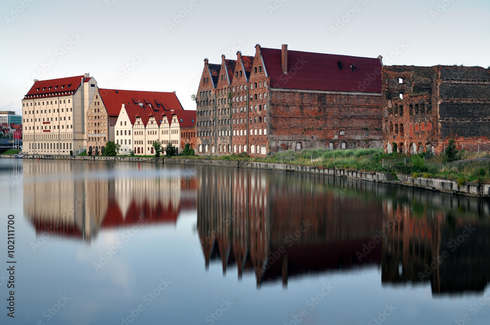 Fototapeta premium Old industrial area of Gdansk, Poland. Coastal homes reflected in water. 