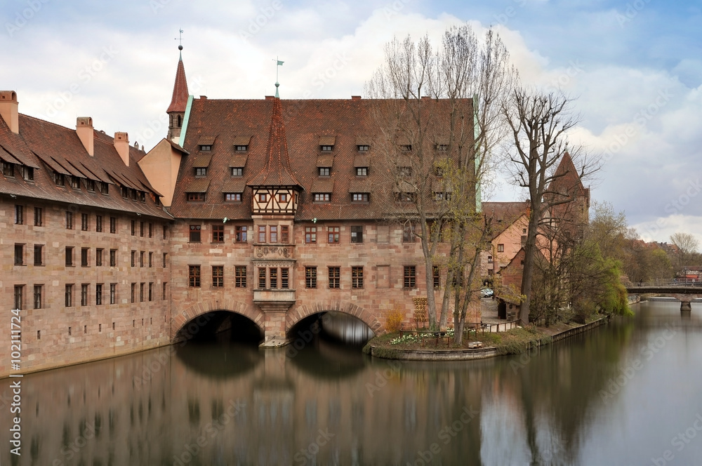 Old buildings and arch bridge reflected in water. Nuremberg, Bayern, Germany