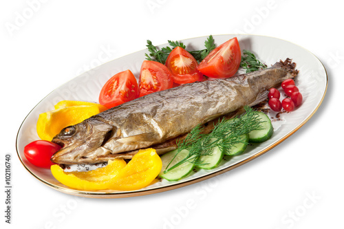 Baked trout with vegetables on the plate on a white background