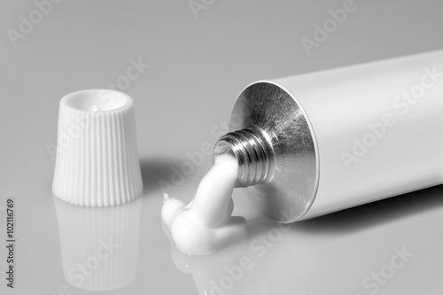 tube of white color on a gray background photo