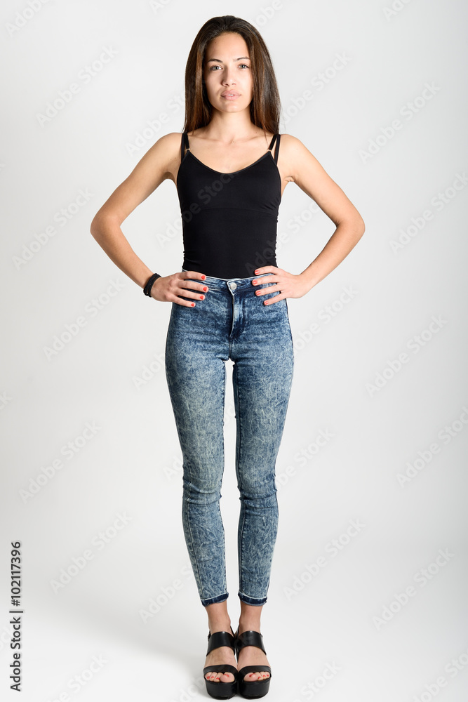 Young woman wearing black tank top and blue jeans Young woman wearing black tank top and blue jeans