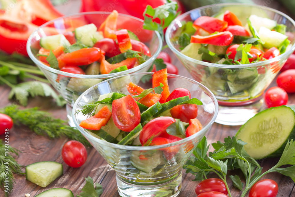 Three glass bowls with a salad of fresh vegetables and ingredients - tomato, cucumber, bell pepper on a dark wooden background
Three glass bowls with a salad of fresh vegetables and ingredients - tomato, cucumber, bell pepper on a dark wooden background