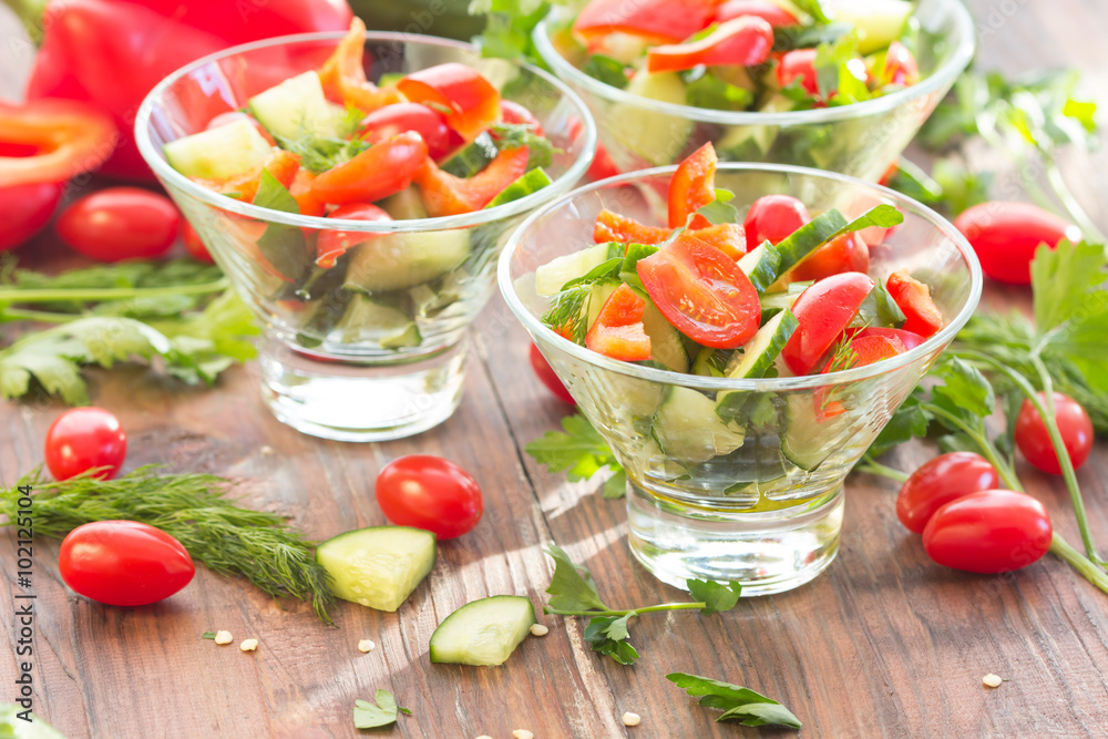 Three glass bowls with a salad of fresh vegetables and ingredients - tomato, cucumber, bell pepper on a dark wooden background
Three glass bowls with a salad of fresh vegetables and ingredients - tomato, cucumber, bell pepper on a dark wooden background