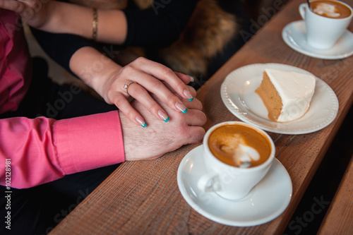 man and woman holding hands in a cozy cafe