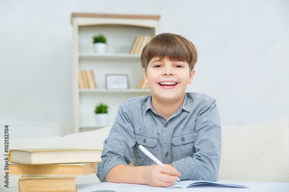 Beautiful happy child smiling while doing homework Beautiful happy child smiling while doing homework