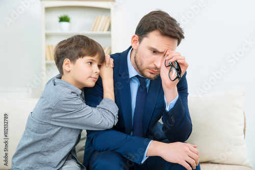 Father is feeling worry while son trying to comfort him