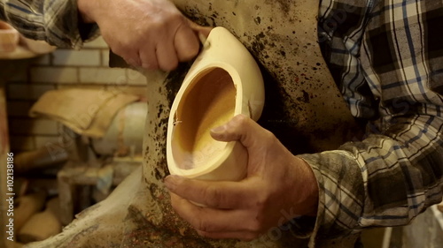 Clog maker is cutting decoration in clog with a gouge