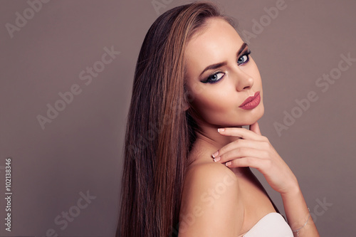 fashion studio portrait of beautiful young woman with blond straight hair and evening makeup 