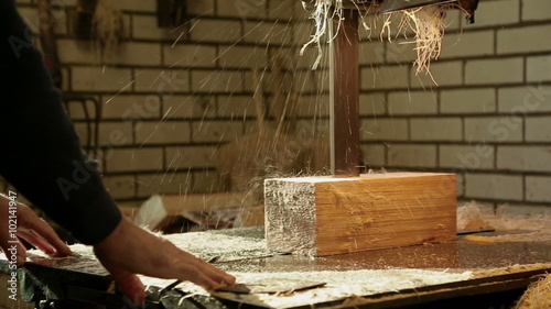 Clog maker sawing wood with a band saw