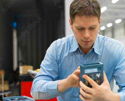 Handsome worker assembling electronic components at the factory.