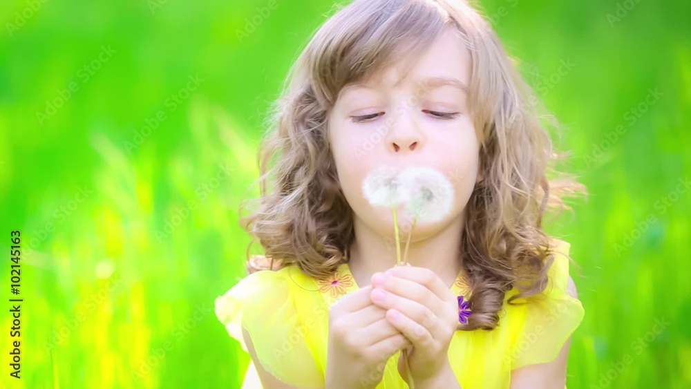 Happy child playing with dandelion outdoors in spring park. Slow motion Happy child playing with dandelion outdoors in spring park. Slow motion