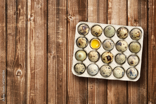 Quail eggs in tray on wooden table top view