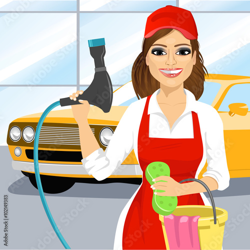 Smiling young girl with a soapy sponge and hose to wash a car