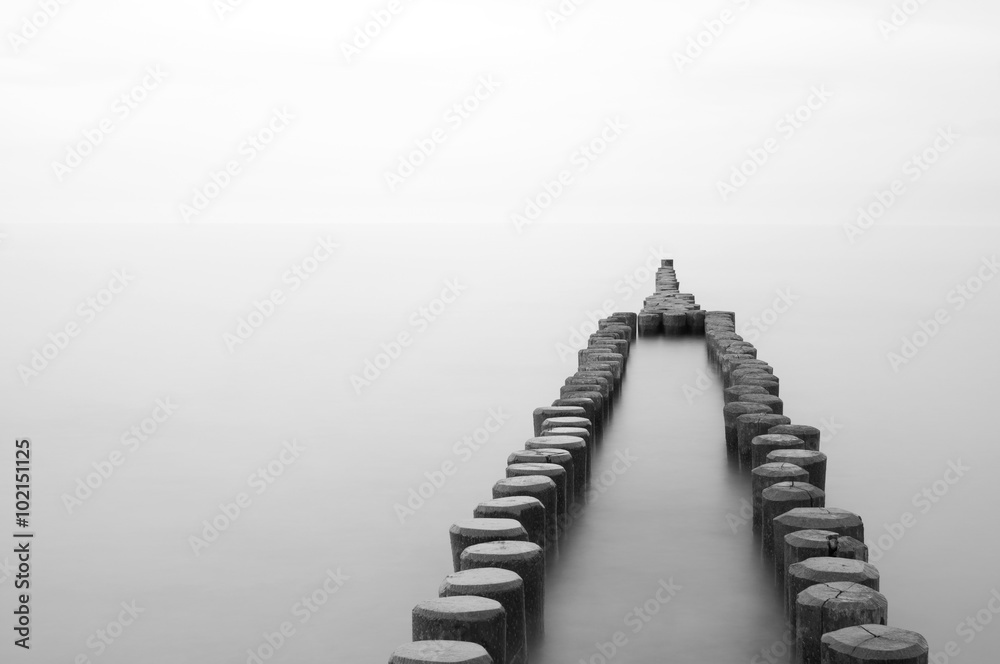 old wooden breakwater at the beach, black and white, long time exposure, German Baltic Sea Coast, Europe - obrazy, fototapety, plakaty 