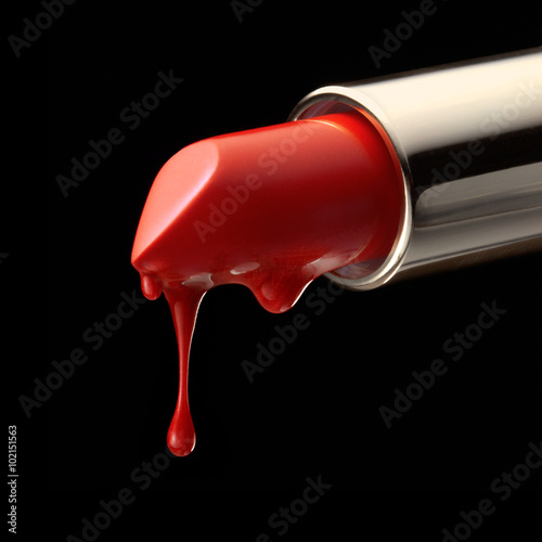 Red melting lipstick isolated on black background photo