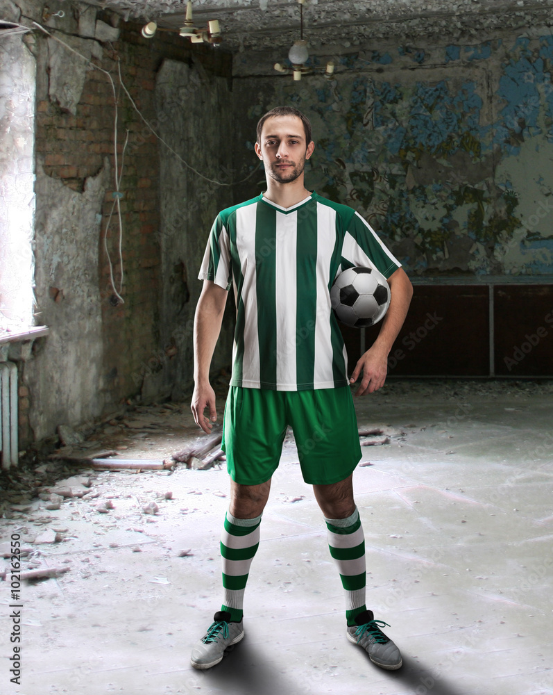 Obraz premium Football-player in a dirty room