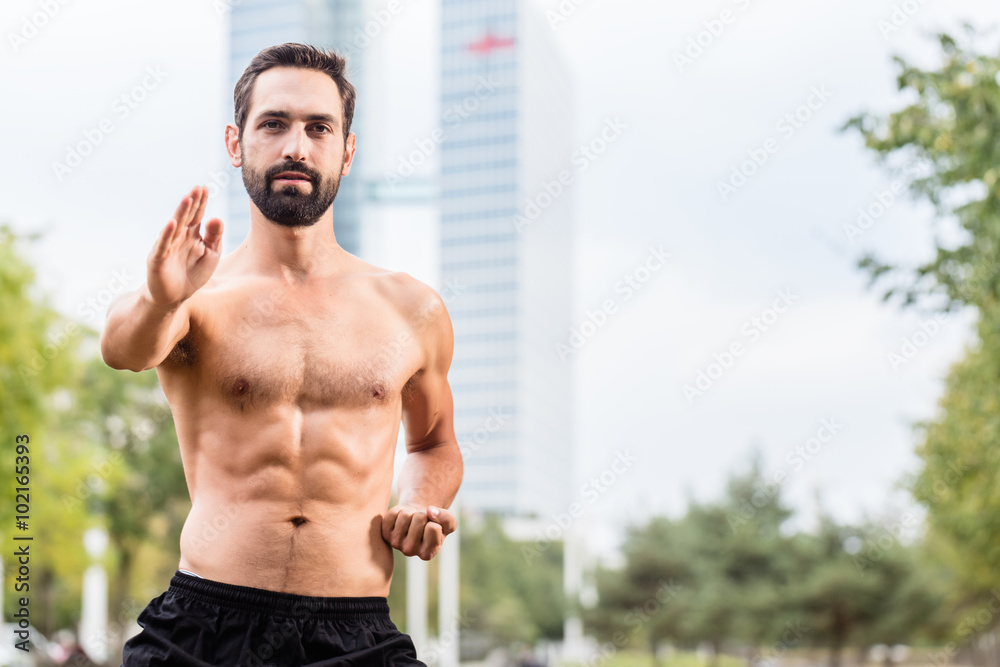 Fototapeta premium Mann bei Qi Gong mit Bürogebäude im Hintergrund
