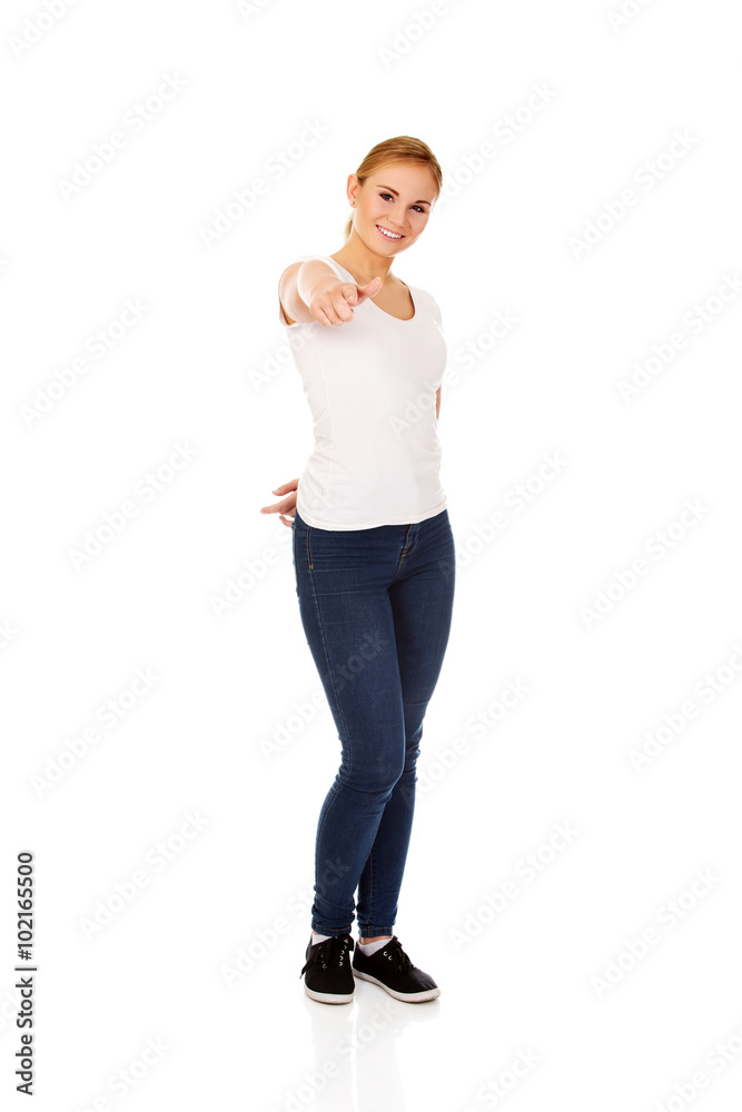 Fototapeta premium Smiling young woman pointing at camera