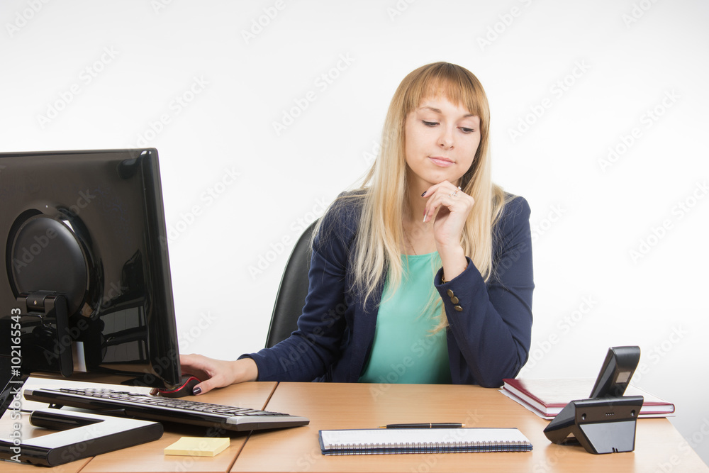 Secretary working at a computer looking at the phone rang Secretary working at a computer looking at the phone rang
