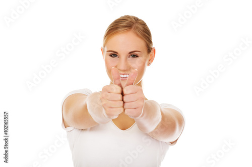 Young happy woman gesturing thumbs up