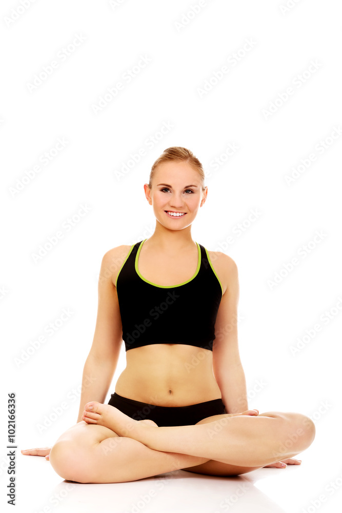 Athletic woman sitting cross legged on the floor Athletic woman sitting cross legged on the floor