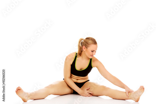 Young woman doing stretching exercise on the floor