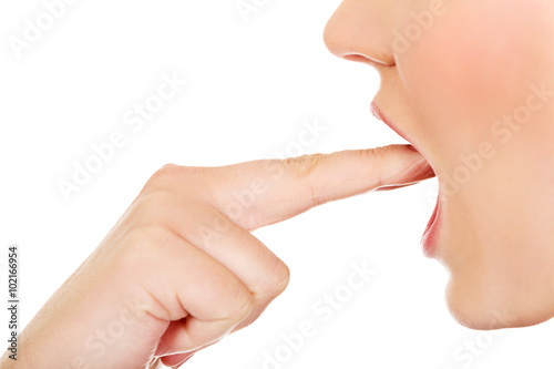 Woman provoke vomiting by putting finger to mouth