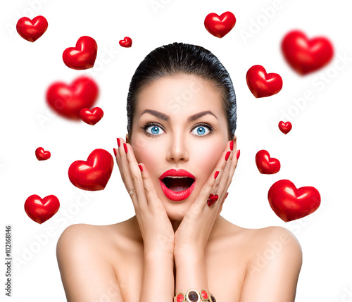 Beauty fashion surprised woman with flying red hearts photo