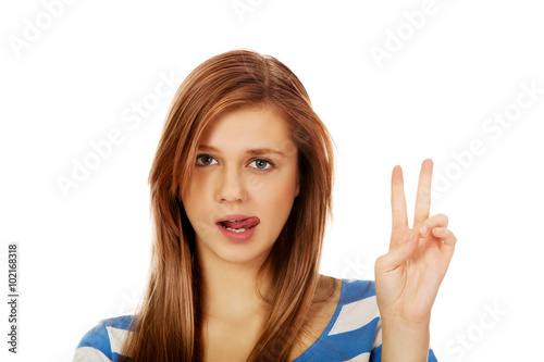 Smiling young woman showing the victory sign