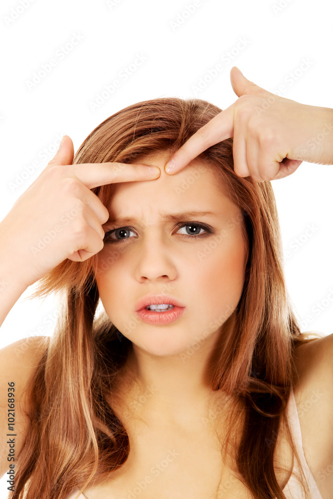 Fototapeta premium Teenage angry woman poping pimple