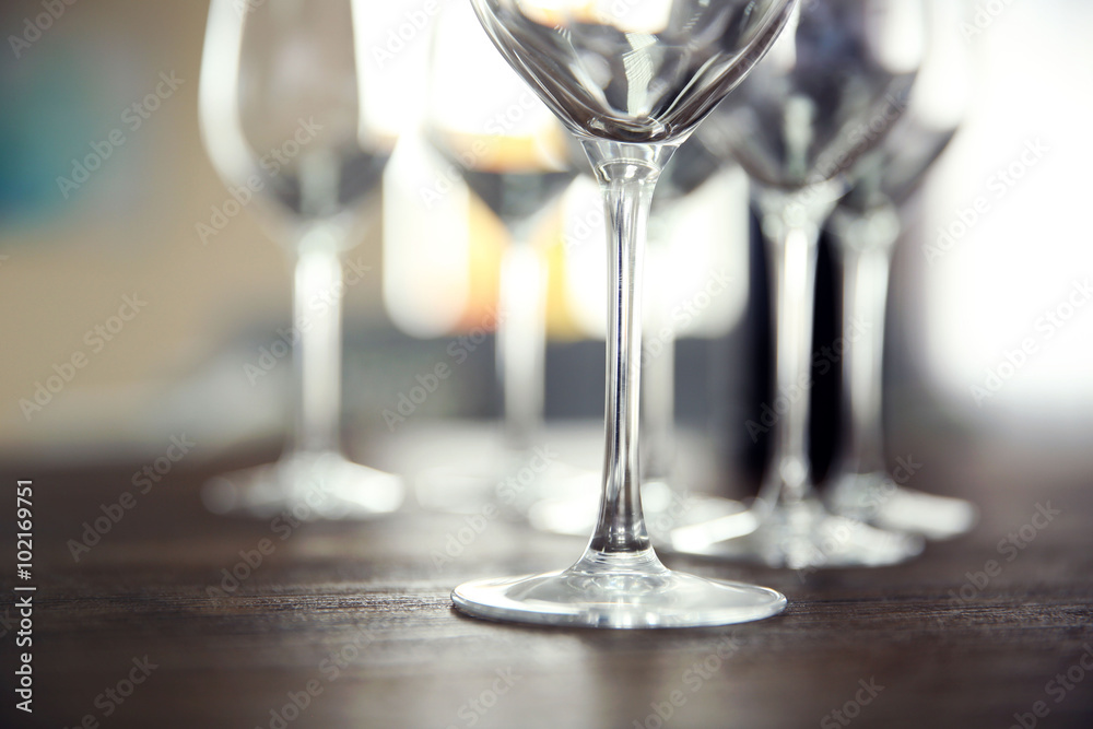 Empty wine glasses with bottle on wooden table against blurred background Empty wine glasses with bottle on wooden table against blurred background