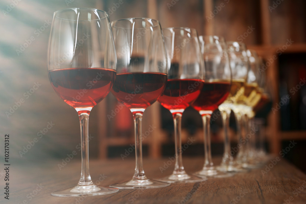 Fototapeta premium Many glasses of different wine in a row on bar counter