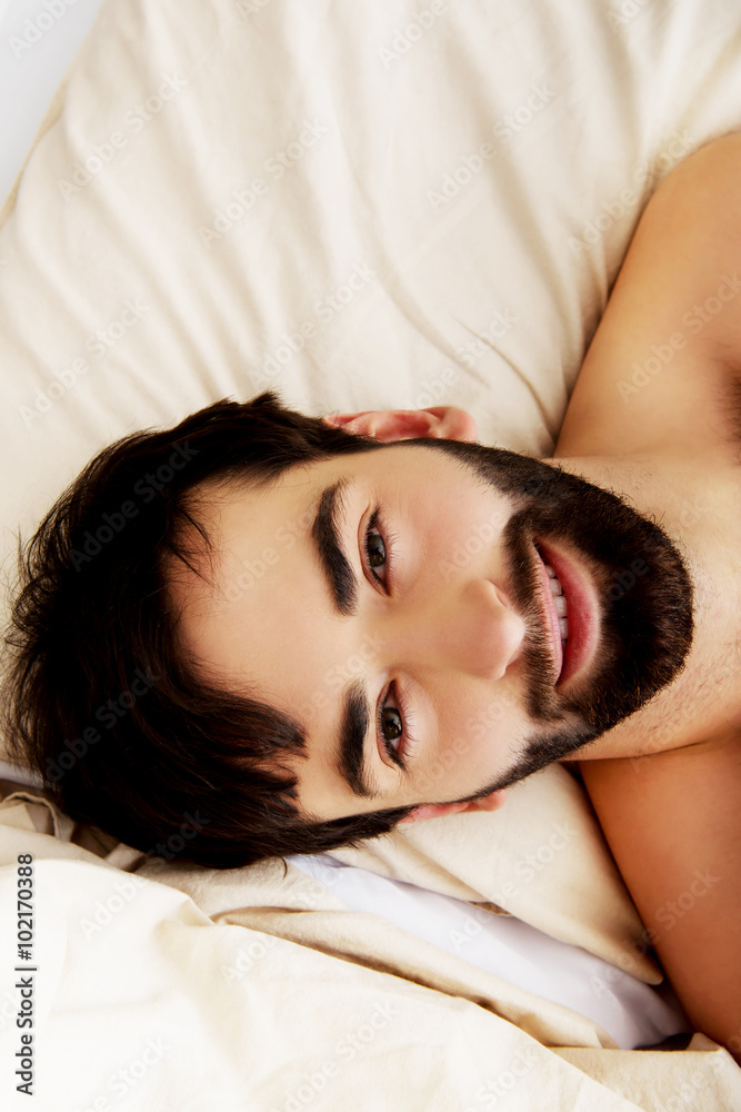 Young muscular man lying in bed. Young muscular man lying in bed.