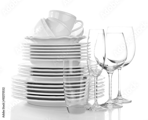 Stack of plates, cups and wineglasses on white background