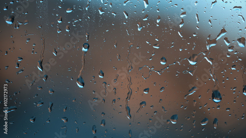 Beautiful blue abstract raindrop pattern on a window at day light. Lovely metal look effect used.