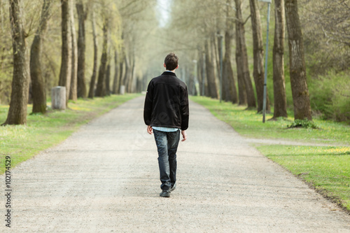 Teenage boy walking down a rural road