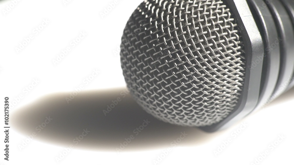 Macro view of a head of a classic handheld microphone steel grid turning left