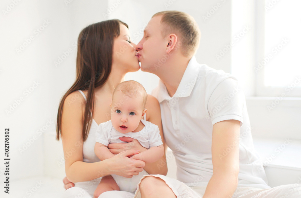 Happy family together home, mother and father with baby in white Happy family together home, mother and father with baby in white