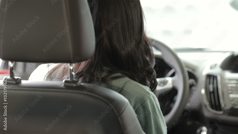 Young woman doing thumps-up in car