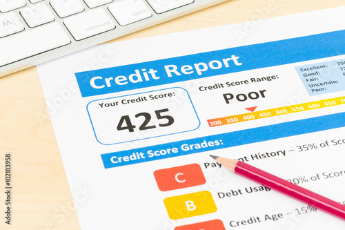 Poor credit score report with pen and keyboard