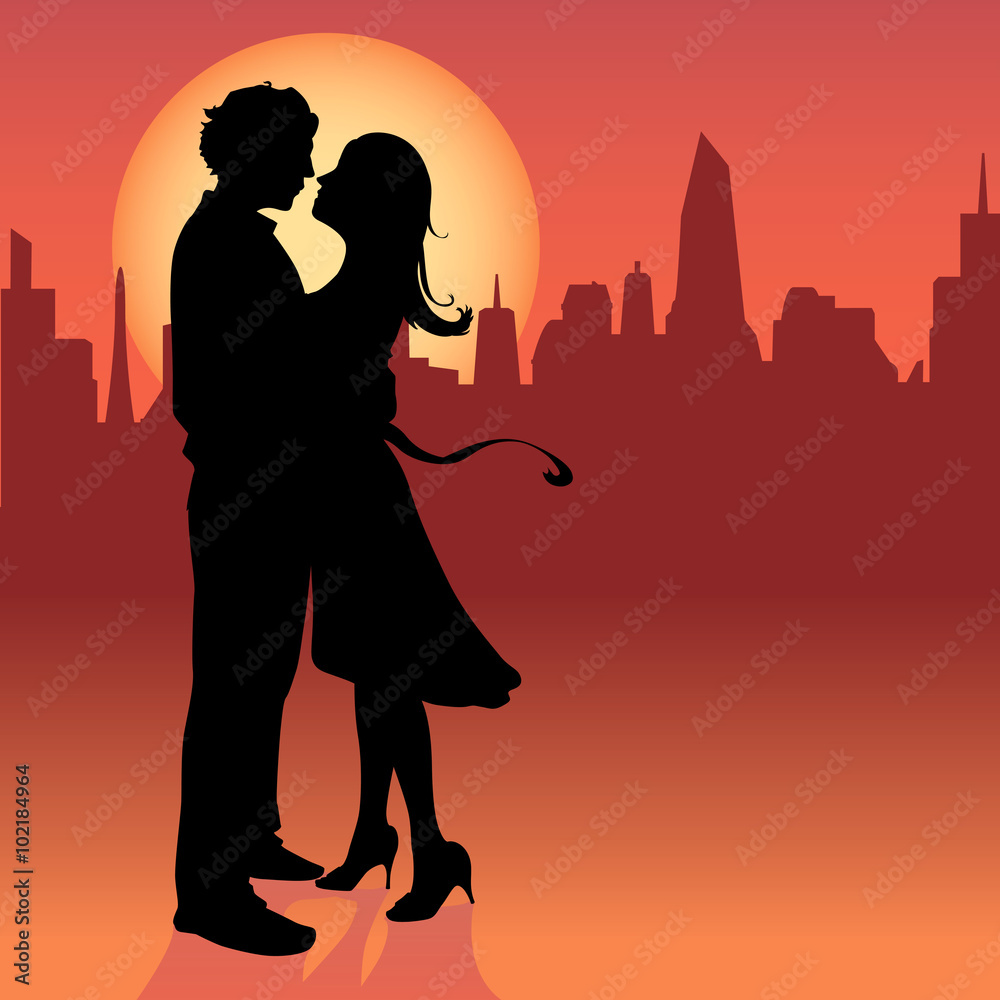 A young couple in silhouettes embrace in love
