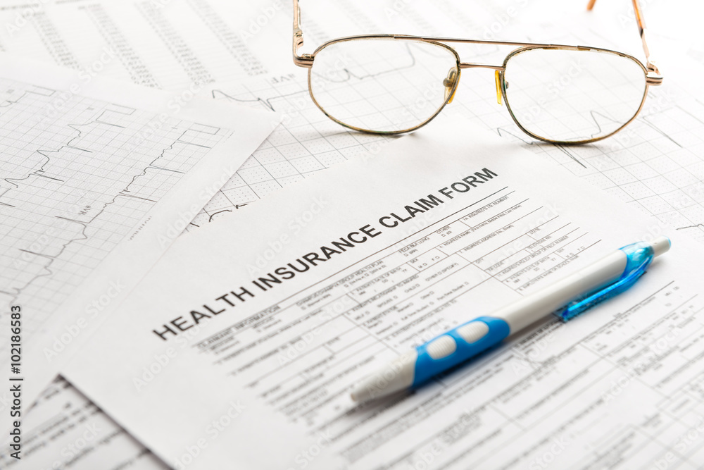 Health insurance claim form with glasses and ballpoint pen. Health insurance claim form with glasses and ballpoint pen.
